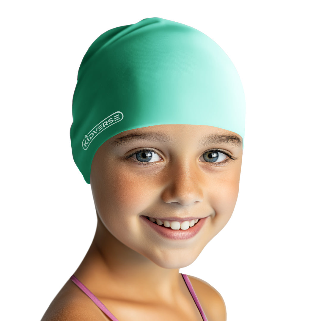 Kind lächelt fröhlich und trägt eine Kinderbadekappe in der Farbe Mint
