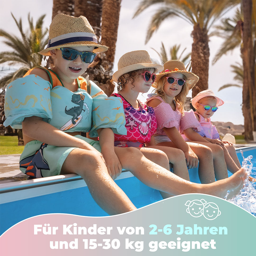 Kinder sitzen am Beckenrand mit den Kidverse Schwimmwesten mit Schwimmflügeln. Text: Für Kinder von 2- 6 Jahren und 15-30kg geeignet