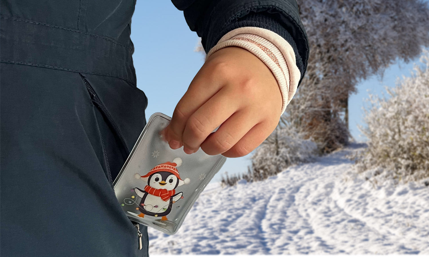 Kind steckt an einem kalten Wintertag einen wiederverwendbaren Handwärmer in die Jackentasche, um die Hände warmzuhalten